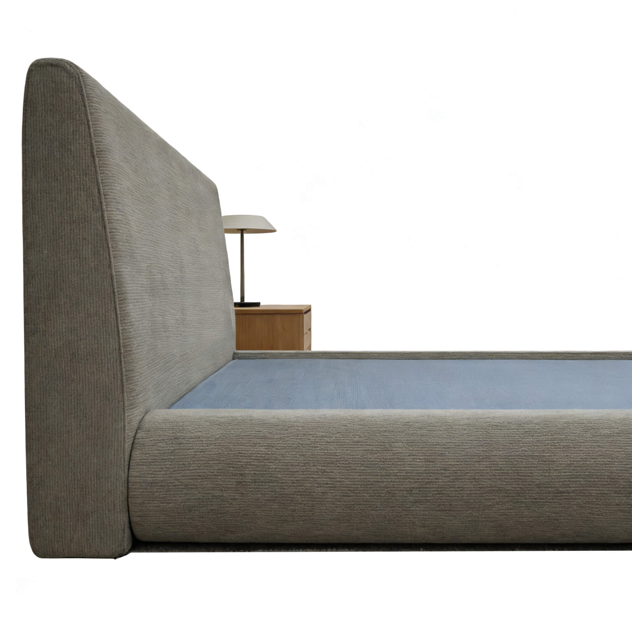 Modern minimalist bedroom interior with a low-profile upholstered bed frame, light grey fabric, and slim headboard design for space optimization