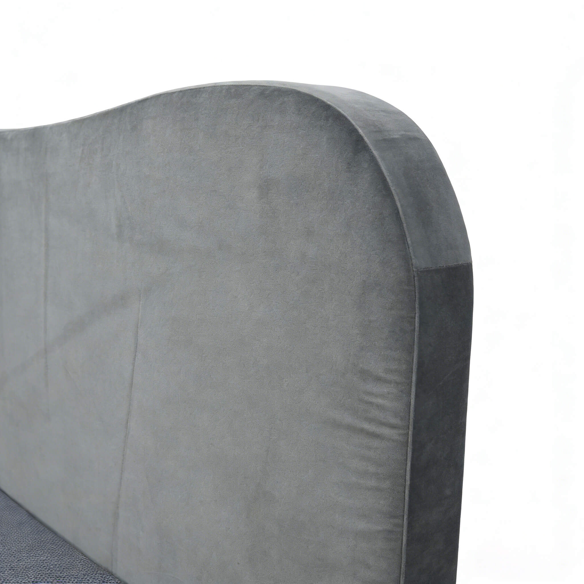 Extreme close-up of the plush, gray fabric camelback headboard, highlighting the soft texture and high-quality foam padding