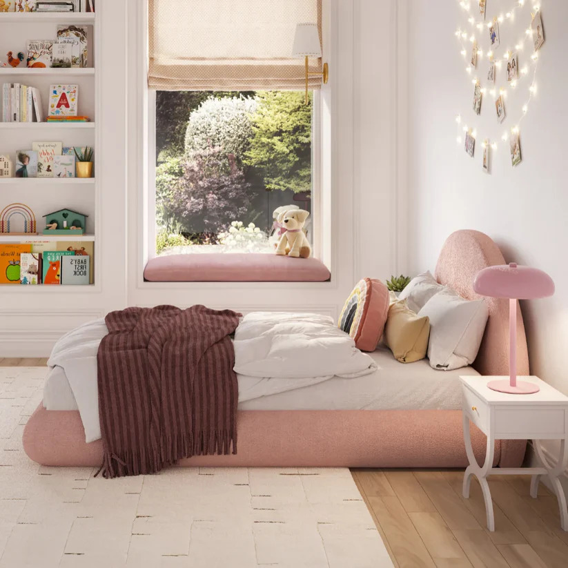 Side view of low-profile pink upholstered children's bed frame showing space-saving design for modern home and hotel nursery rooms