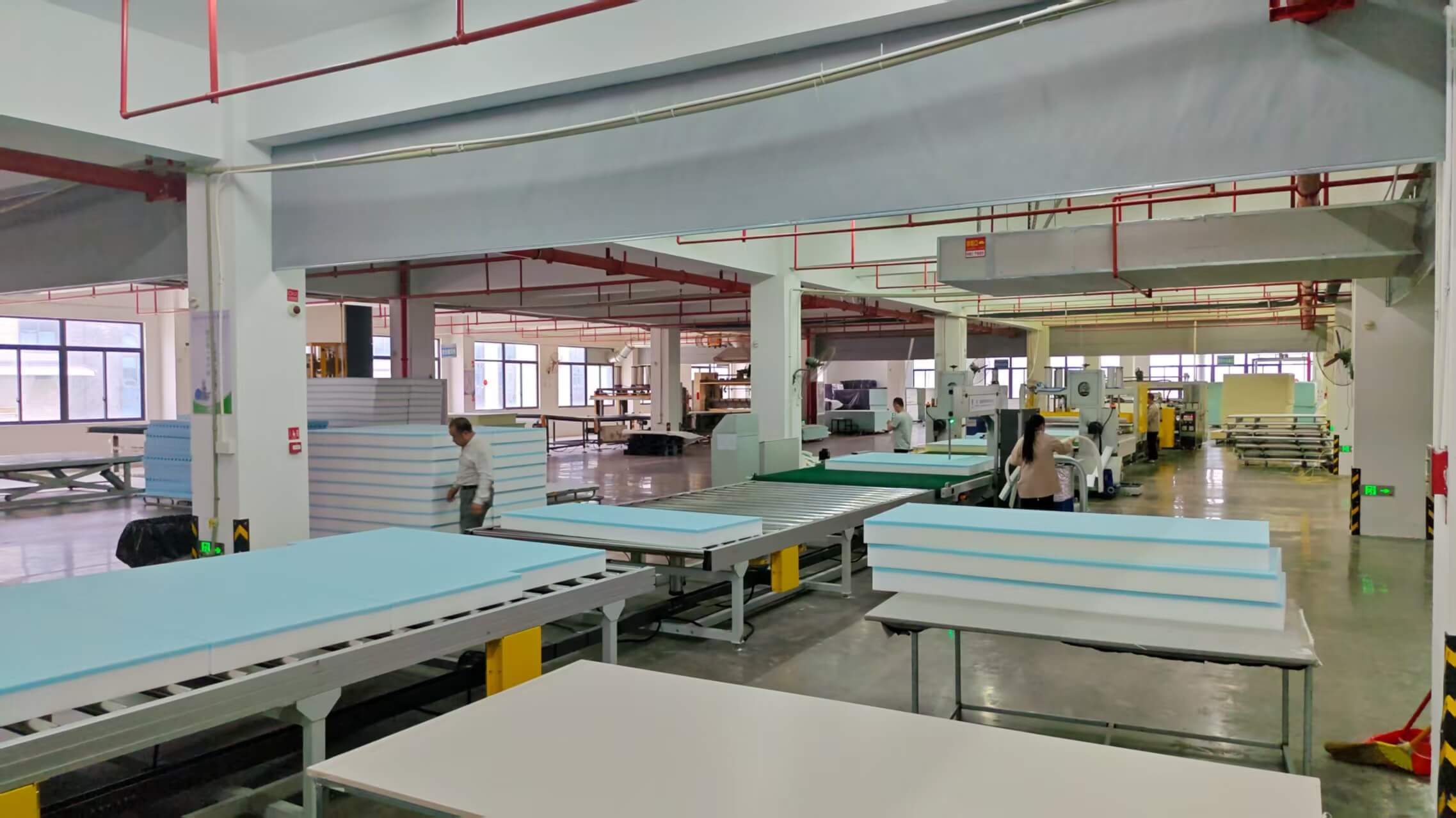 A professional operator at the MX Dream factory managing an automated vacuum compression machine for large foam furniture, ensuring high-efficiency production and quality control A professional operator at the MX Dream factory managing an automated vacuum compression machine for large foam furniture, ensuring high-efficiency production and quality control