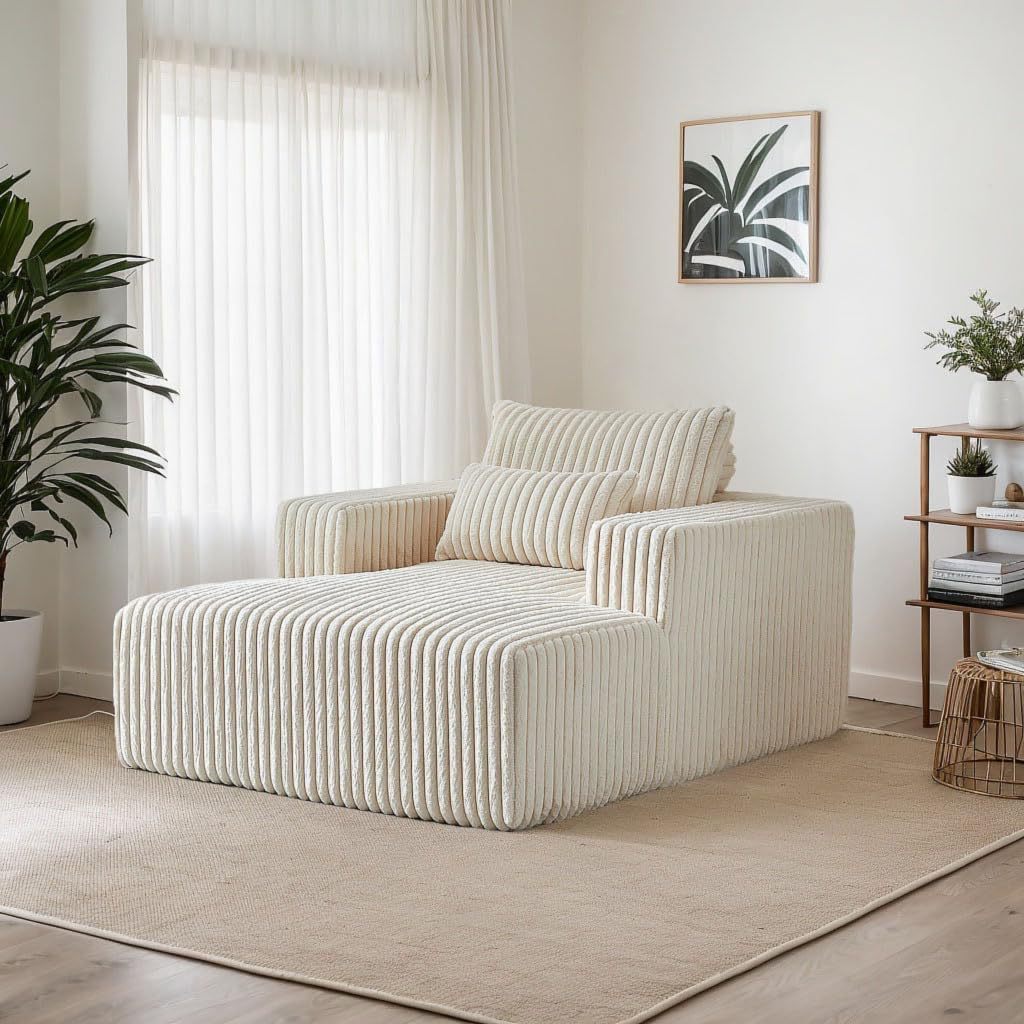 Cream white corduroy modular chaise lounge sofa in a bright modern living room with plants