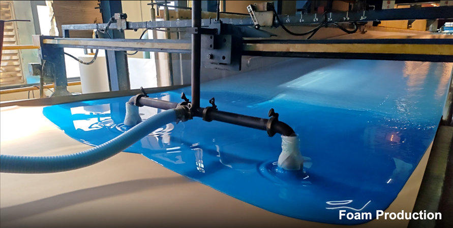 High-definition close-up of the foam production (foaming) process. Blue and white chemical precursors are being dispensed and mixed to create high-density foam for vacuum-compressed sofas. This visual supports our vertical integration narrative to guarantee on-time shipping for B2B buyers.