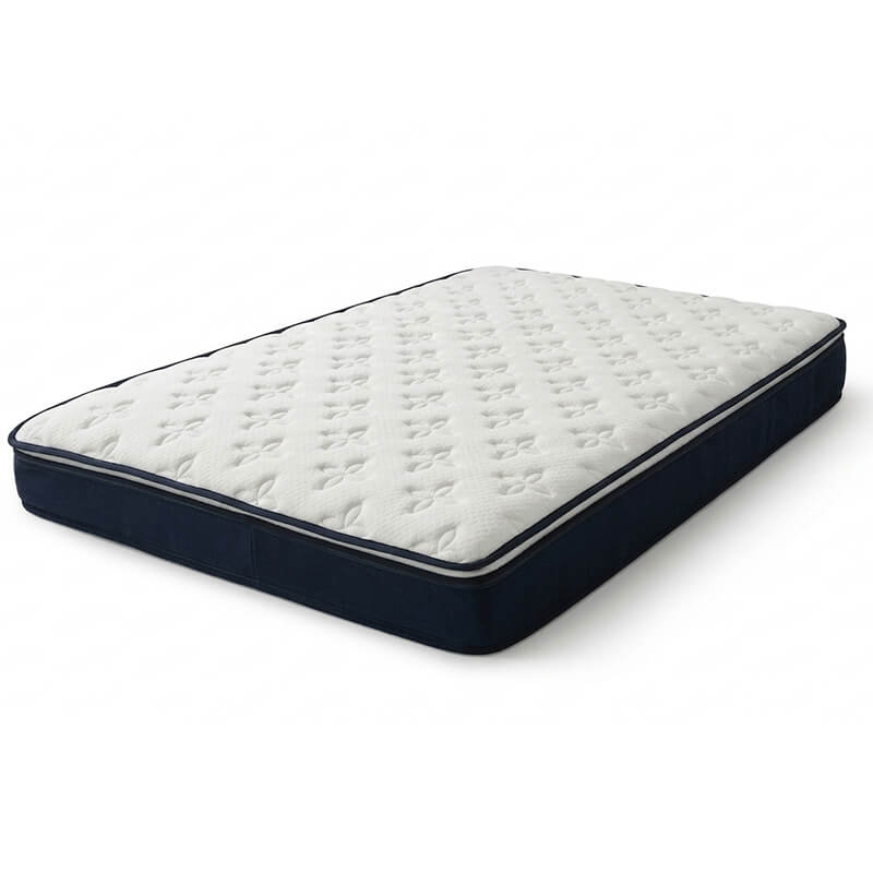 Angled studio shot of a full-size foam mattress featuring an elegant white quilted floral patterned cover and dark navy blue fabric side borders on a clean white background