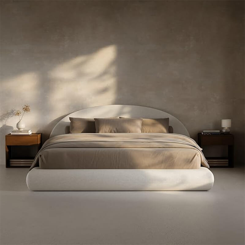 Minimalist neutral bedroom interior featuring a curved upholstered platform bed